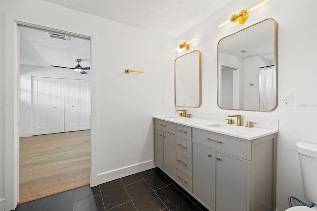 bathroom featuring ceiling fan, hardwood / wood-style floors, a textured ceiling, toilet, and vanity