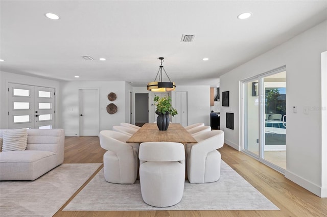 dining space with french doors and light hardwood / wood-style flooring