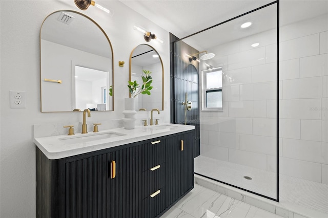 bathroom with a tile shower and vanity