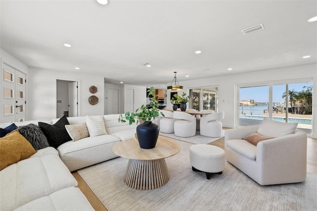 living room with a water view and light hardwood / wood-style floors