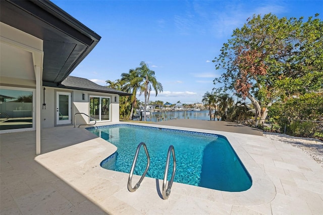 view of pool featuring a patio area and a water view