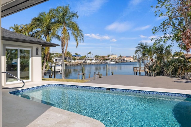 view of swimming pool featuring a boat dock, a water view, and a patio area