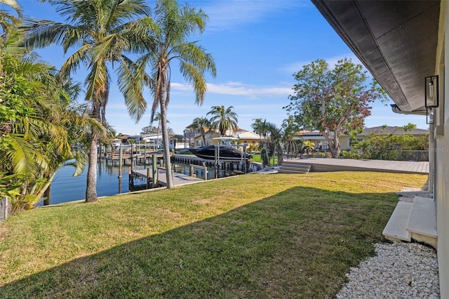 view of dock with a water view and a lawn