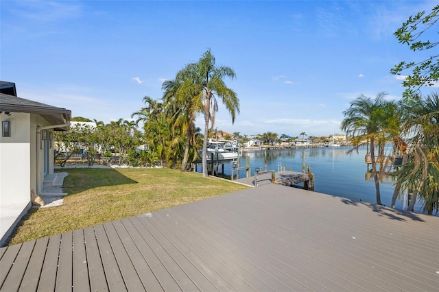 view of dock with a water view and a lawn