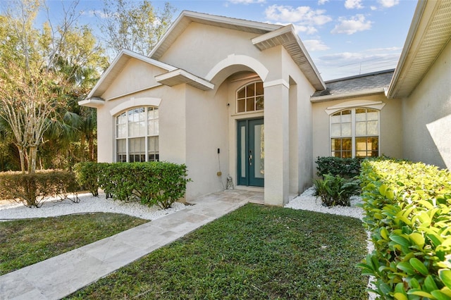 entrance to property with a lawn