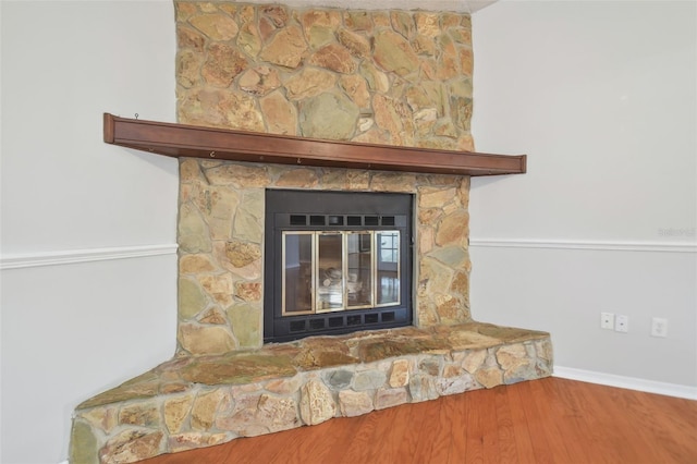 details featuring a stone fireplace and hardwood / wood-style flooring