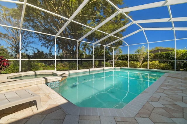 view of swimming pool featuring glass enclosure, an in ground hot tub, and a patio area