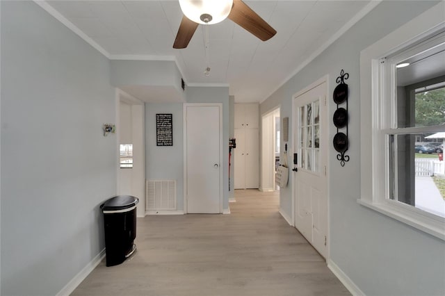 hallway with light hardwood / wood-style floors and ornamental molding