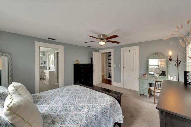 carpeted bedroom with ceiling fan and connected bathroom