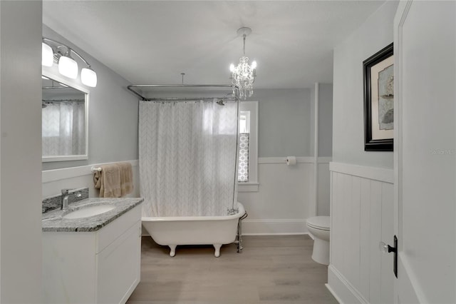 bathroom with hardwood / wood-style floors, vanity, a chandelier, and toilet