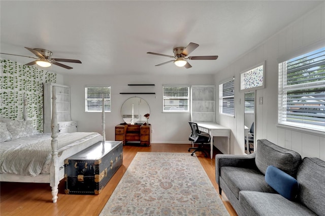 bedroom with hardwood / wood-style floors, multiple windows, and ceiling fan