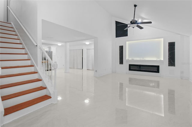 living room with ceiling fan and a high ceiling