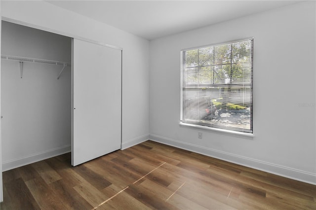 unfurnished bedroom featuring dark hardwood / wood-style floors and a closet