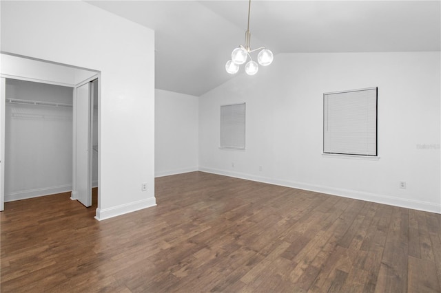 interior space with dark hardwood / wood-style floors, a closet, a chandelier, and vaulted ceiling