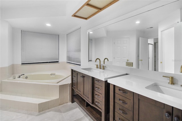 bathroom featuring vanity, tiled bath, and tile patterned floors