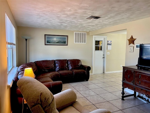 tiled living room with plenty of natural light and a textured ceiling