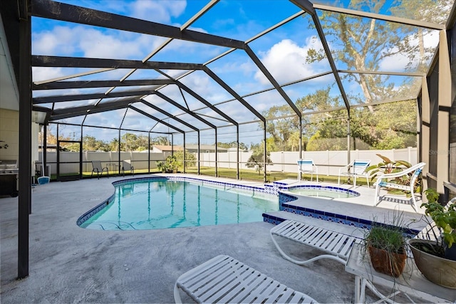 view of swimming pool featuring glass enclosure, an in ground hot tub, and a patio area