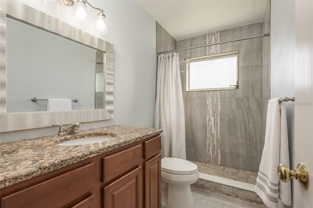 bathroom with tile patterned floors, vanity, toilet, and curtained shower