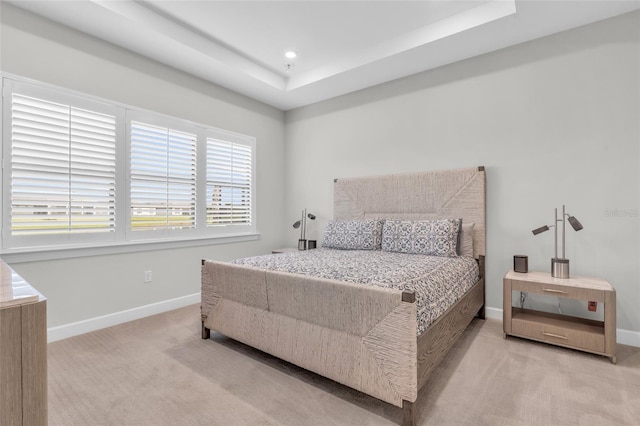 carpeted bedroom featuring a tray ceiling