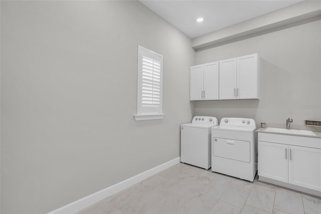 laundry room with washing machine and clothes dryer, cabinets, and sink