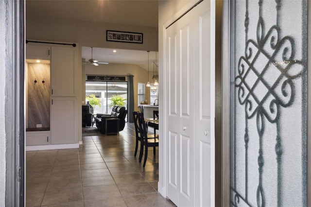 corridor featuring tile patterned flooring and a chandelier