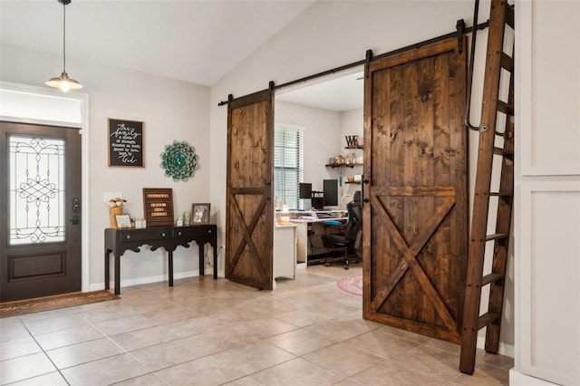 foyer entrance featuring a barn door, lofted ceiling, and light tile patterned floors