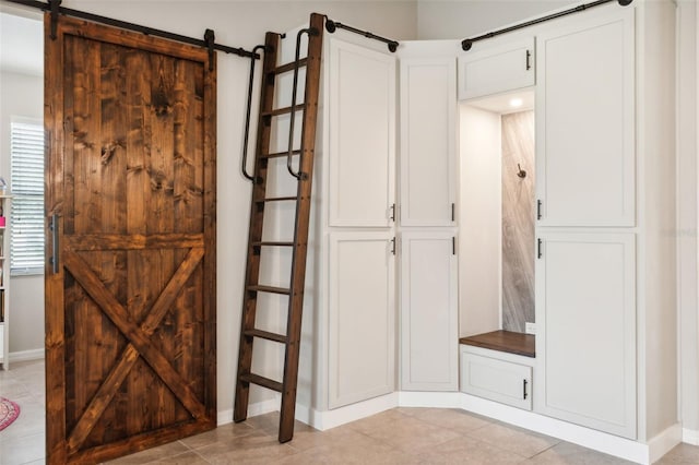 interior space featuring a barn door and light tile patterned floors