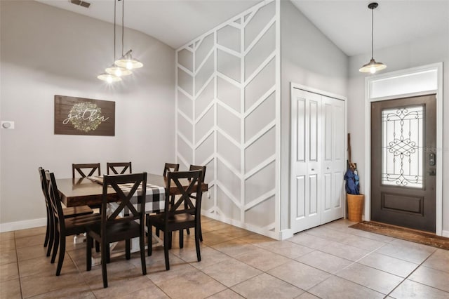 tiled dining room with vaulted ceiling