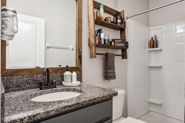 bathroom featuring walk in shower, vanity, and toilet