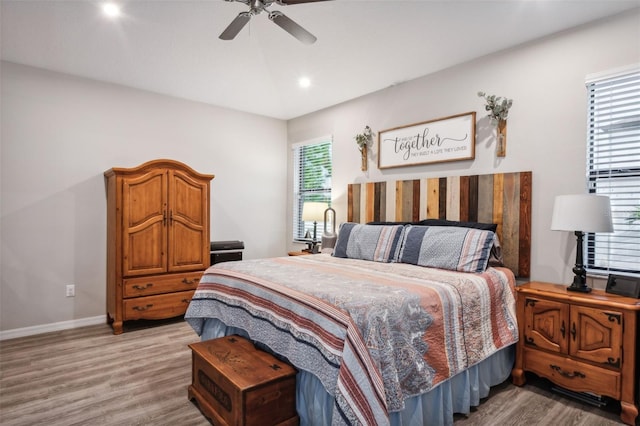 bedroom with hardwood / wood-style floors and multiple windows