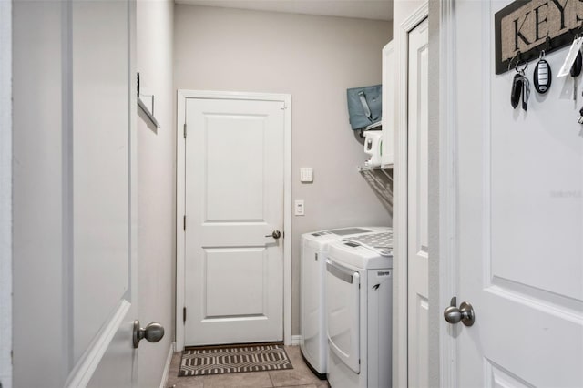 laundry area featuring cabinets, washer and clothes dryer, and light tile patterned flooring