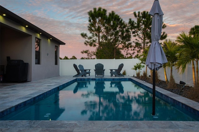 pool at dusk with a patio