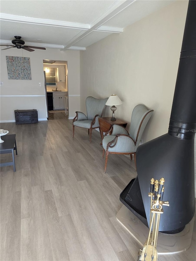 living room with beamed ceiling, light wood-type flooring, and ceiling fan