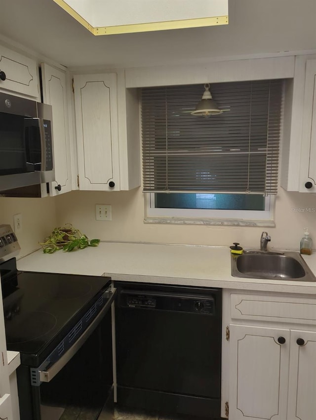 kitchen featuring black appliances, white cabinetry, and sink