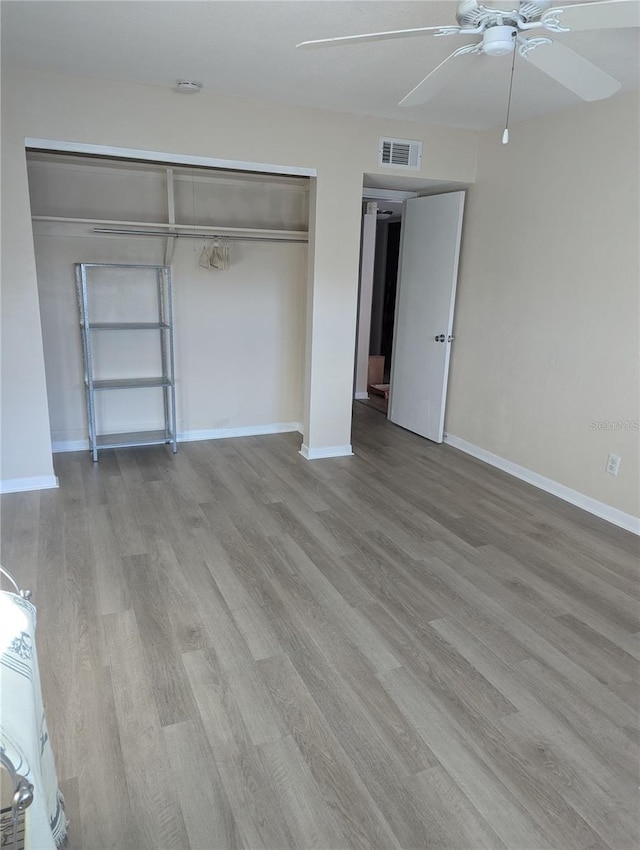 unfurnished bedroom featuring a closet, light hardwood / wood-style floors, and ceiling fan