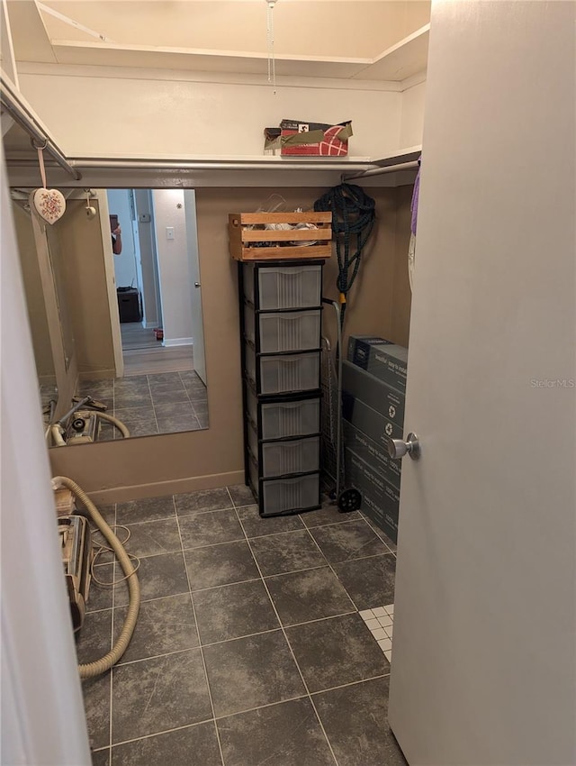 walk in closet with dark tile patterned floors