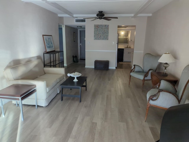 living room with light wood-style floors, ceiling fan, beam ceiling, and baseboards