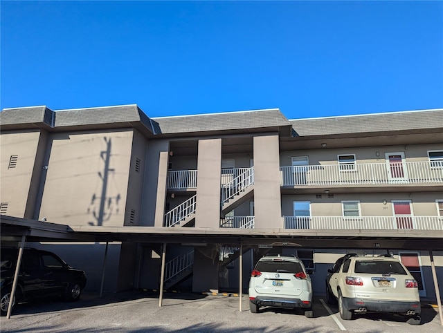 view of property with stairway and covered parking