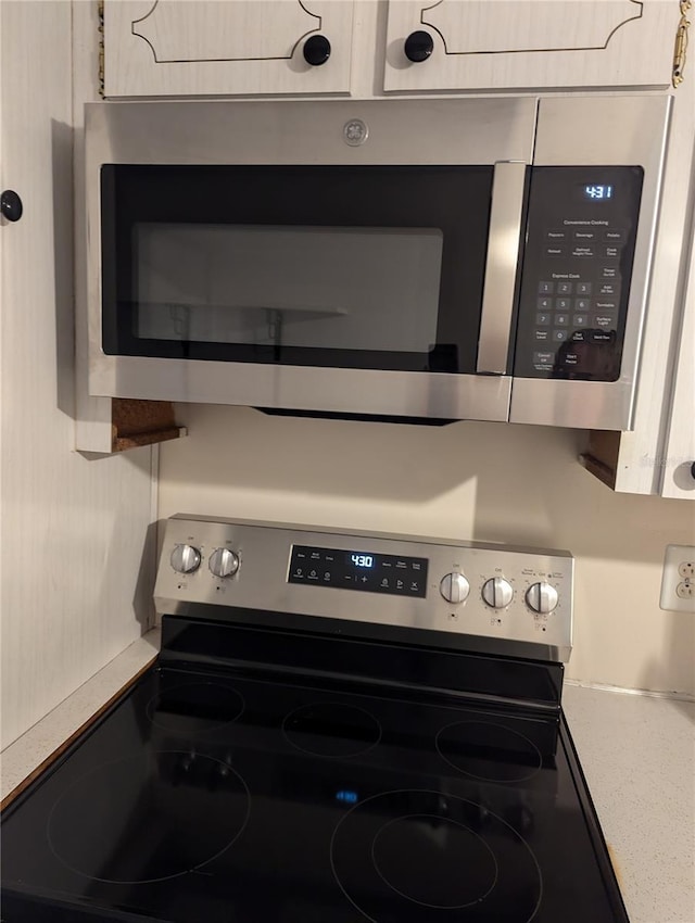 kitchen view of appliances with stainless steel finishes, light countertops, and mail area