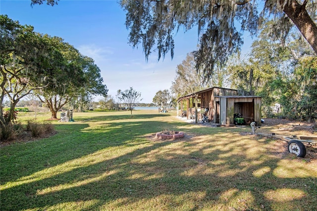 view of yard with a fire pit and an outdoor structure