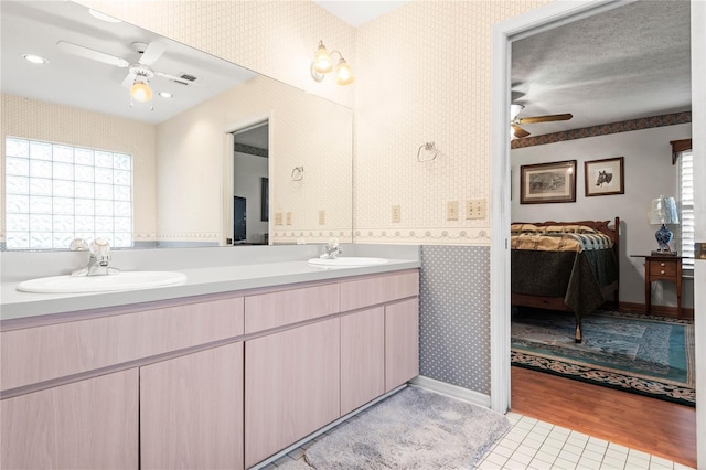 bathroom featuring wood-type flooring, vanity, ceiling fan, and a healthy amount of sunlight