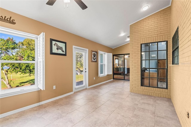 unfurnished room featuring ceiling fan, lofted ceiling, and light tile patterned flooring