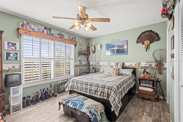 bedroom featuring hardwood / wood-style floors, ceiling fan, and a textured ceiling