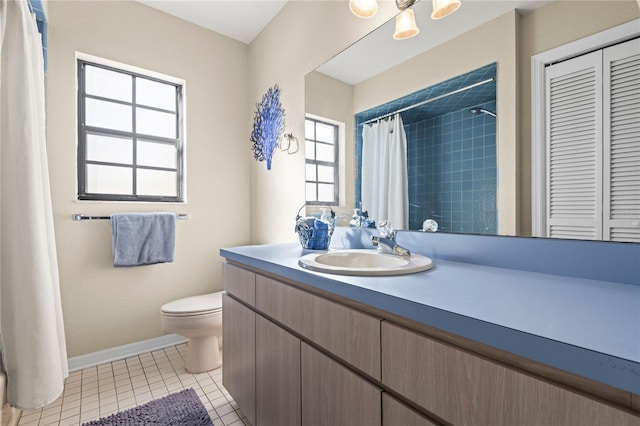 bathroom with tile patterned floors, plenty of natural light, toilet, and vanity