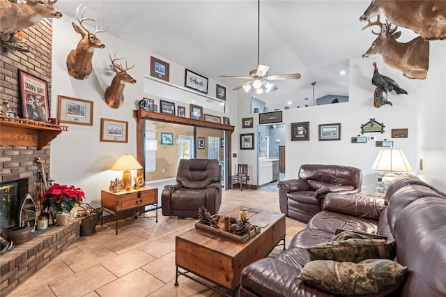 living room featuring ceiling fan, high vaulted ceiling, light tile patterned floors, and a brick fireplace