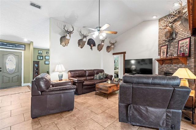 living room with ceiling fan, a fireplace, light tile patterned floors, and vaulted ceiling