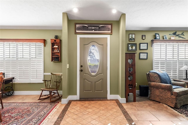 entrance foyer featuring a textured ceiling and light tile patterned flooring