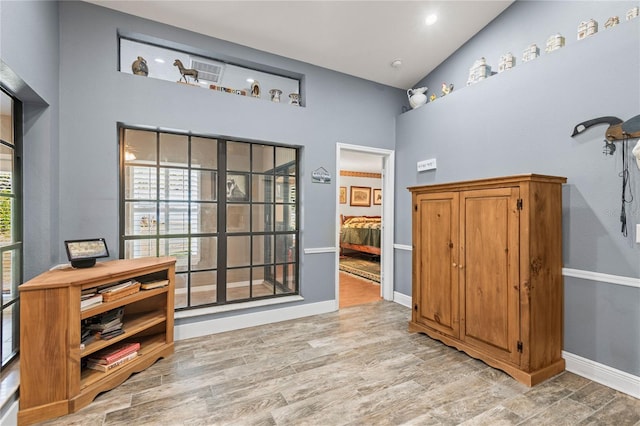 interior space with light hardwood / wood-style flooring and high vaulted ceiling