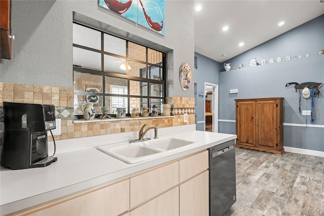 kitchen with sink, black dishwasher, light hardwood / wood-style flooring, lofted ceiling, and decorative backsplash