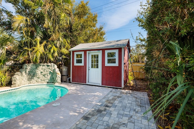 view of pool featuring a patio area and a storage shed